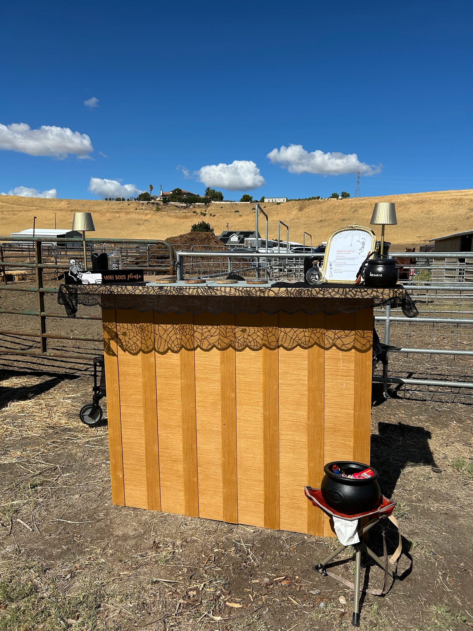 Pour It Out mobile bar set up outdoors at a ranch under blue skies with rolling golden hills in the background